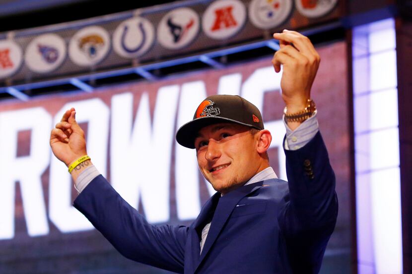 Johnny Manziel (Texas A&M) gestures as he walks across the stage after being selected as the...