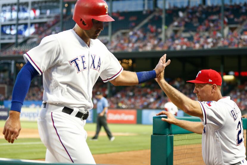 Texas Rangers' Joey Gallo, left, celebrates his run scored with manager Jeff Banister (28)...