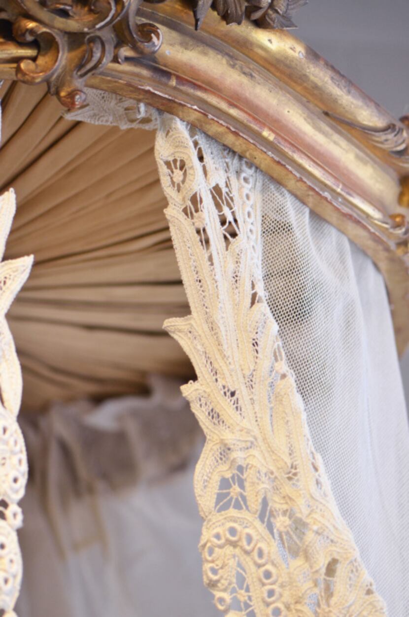 A piece of repurposed European lace is attached to an antique carved bed crown. Installed...