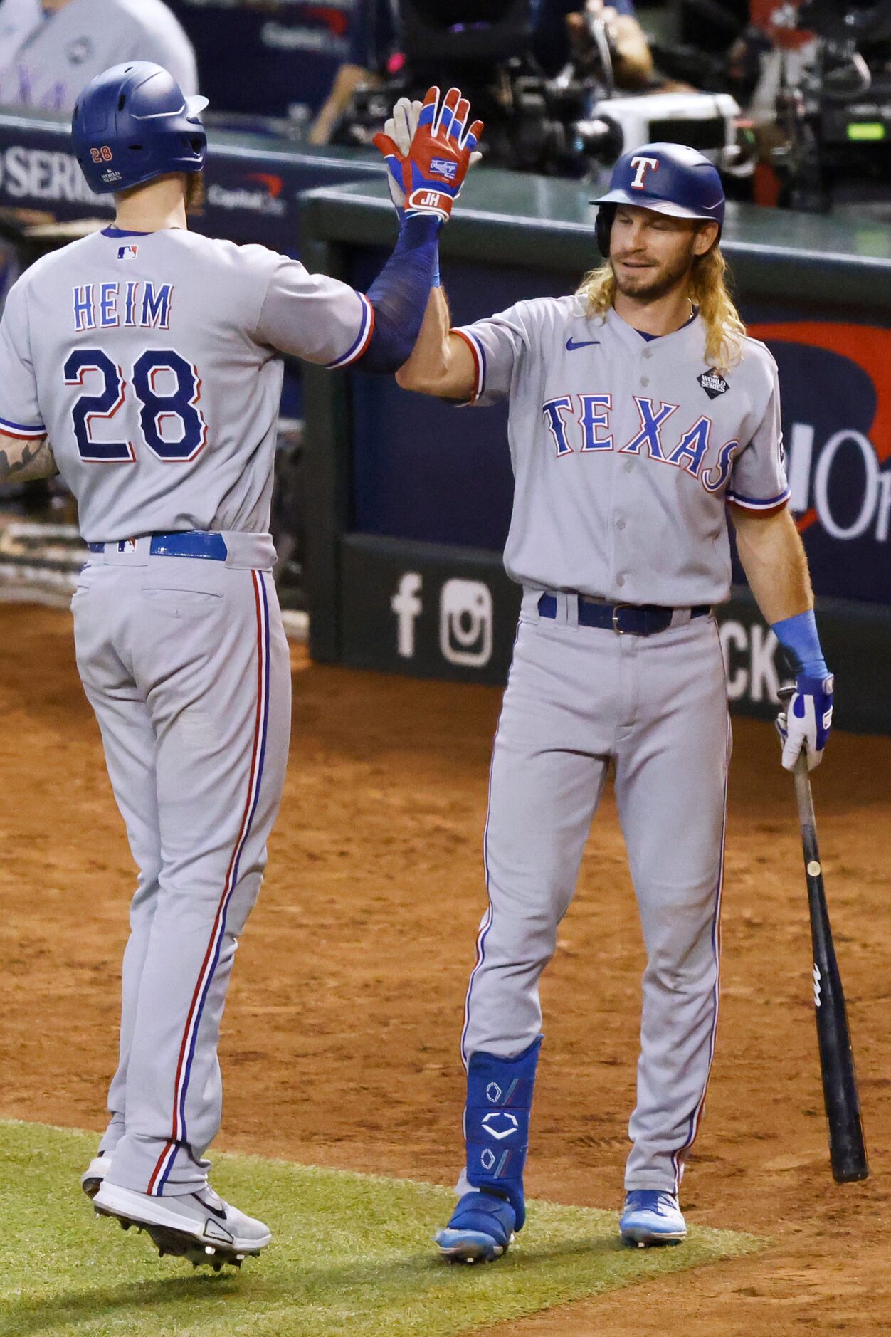 Texas Rangers’ Jonah Heim is congratulated by Travis Jankowski, right, after hitting solo...