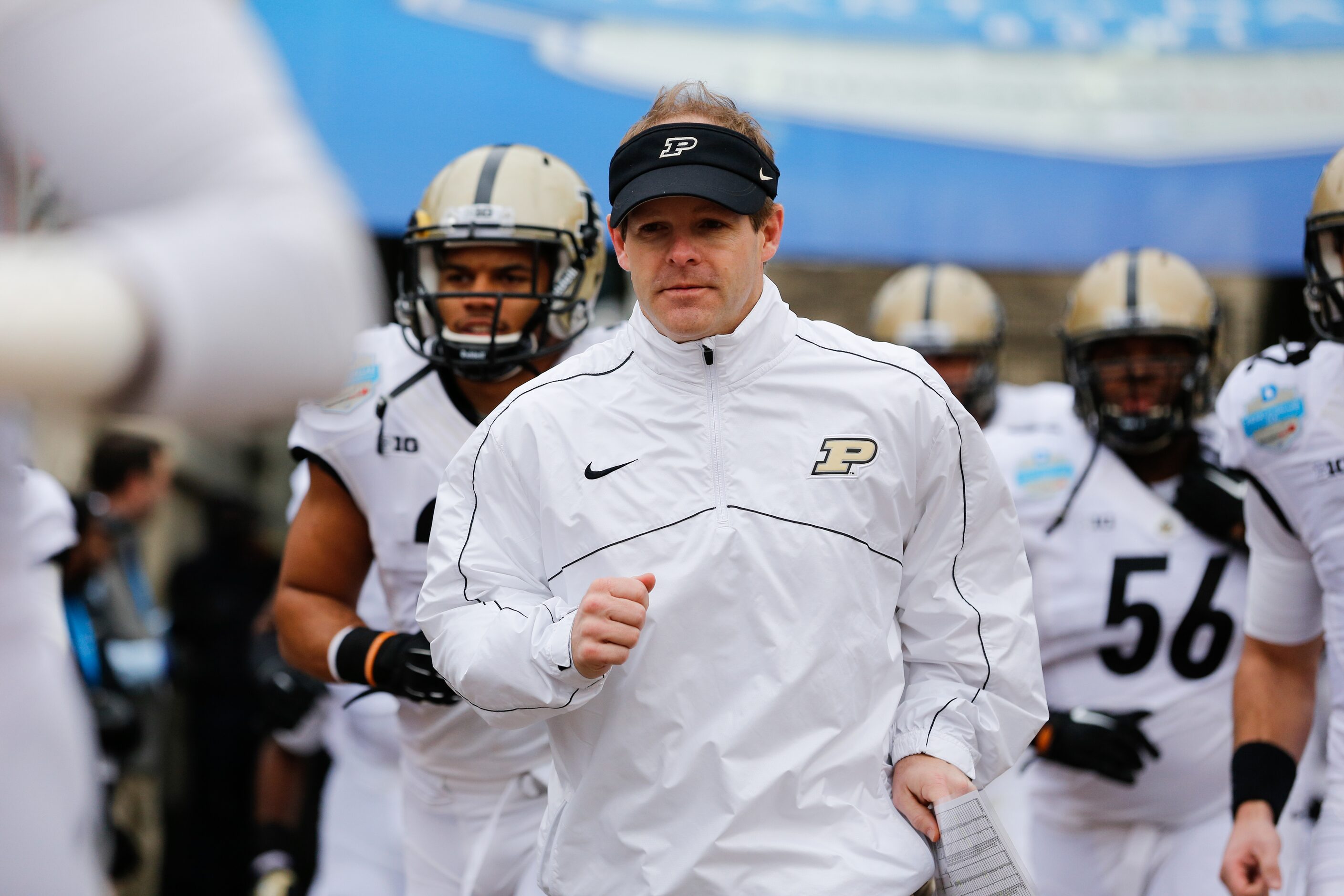 Purdue's interim head coach Patrick Higgins runs onto the field with his team during the...