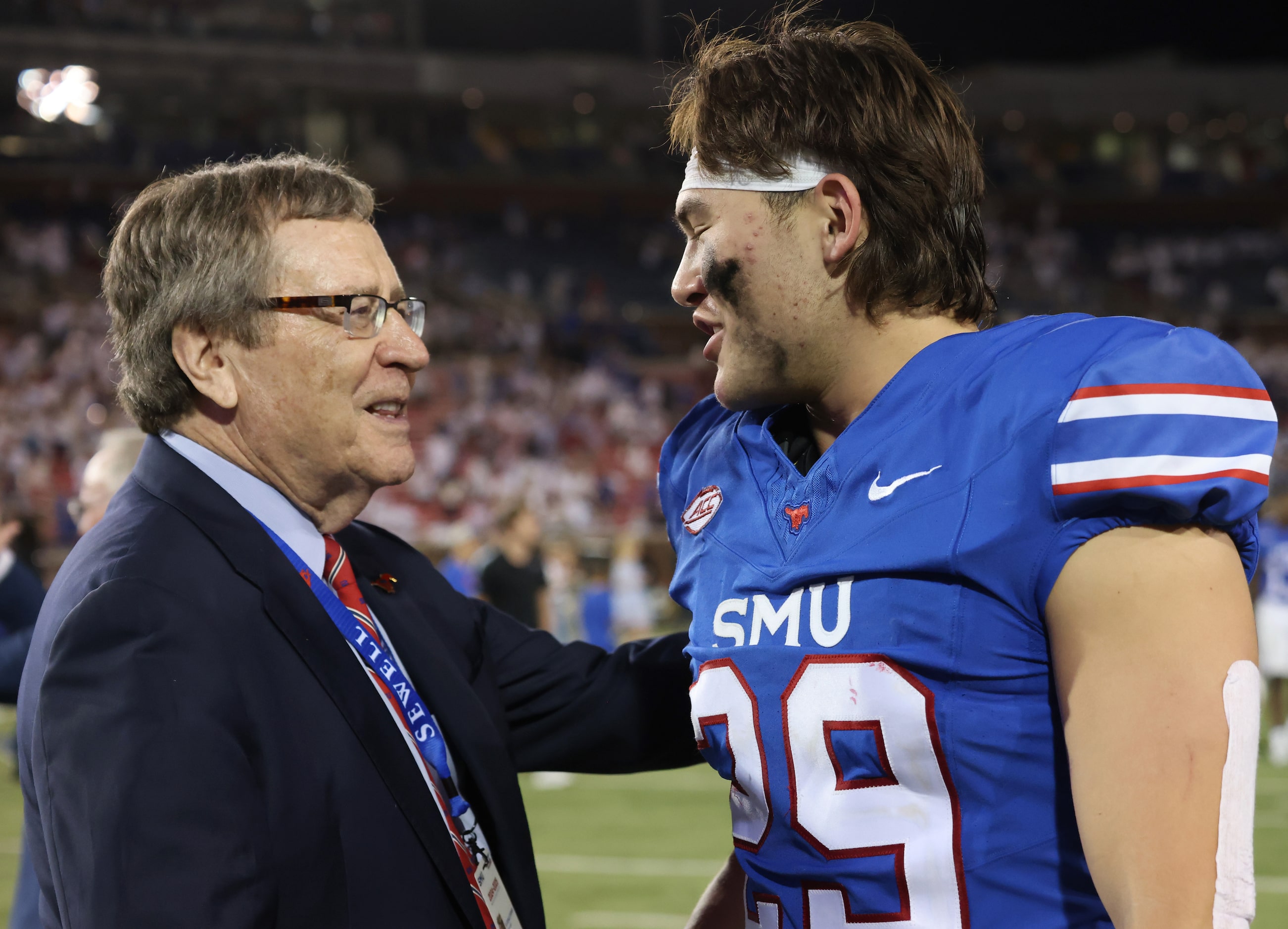 SMU President R. Jerald Turner congratulates Mustangs linebacker Brandon Miyazono (29) after...