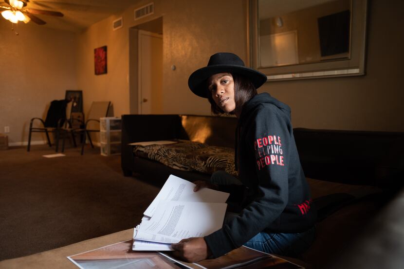 Brittany Jones, 40, sits in her living room with stacks of emails to apartment managers...