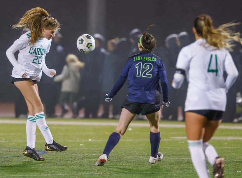 Southlake Carroll High School sophomore defender Abby Mills (20) heads the ball downfield...