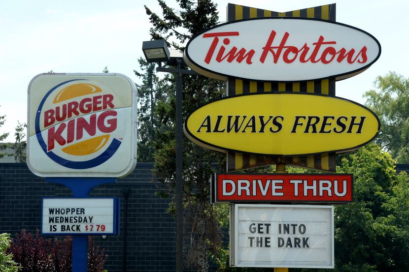 A Burger King sign and a Tim Hortons sign are displayed in Ottawa, Ontario, Monday, Aug. 25,...