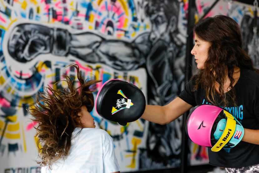 Amanda Alvarez, a salsa teacher and boxing lover, trains her daughter Isa, 7, during a...