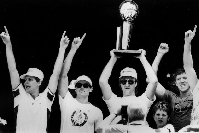 ORG XMIT: APHS222826 Larry Bird holds the NBA trophy aloft as his Celtic teammates, from...