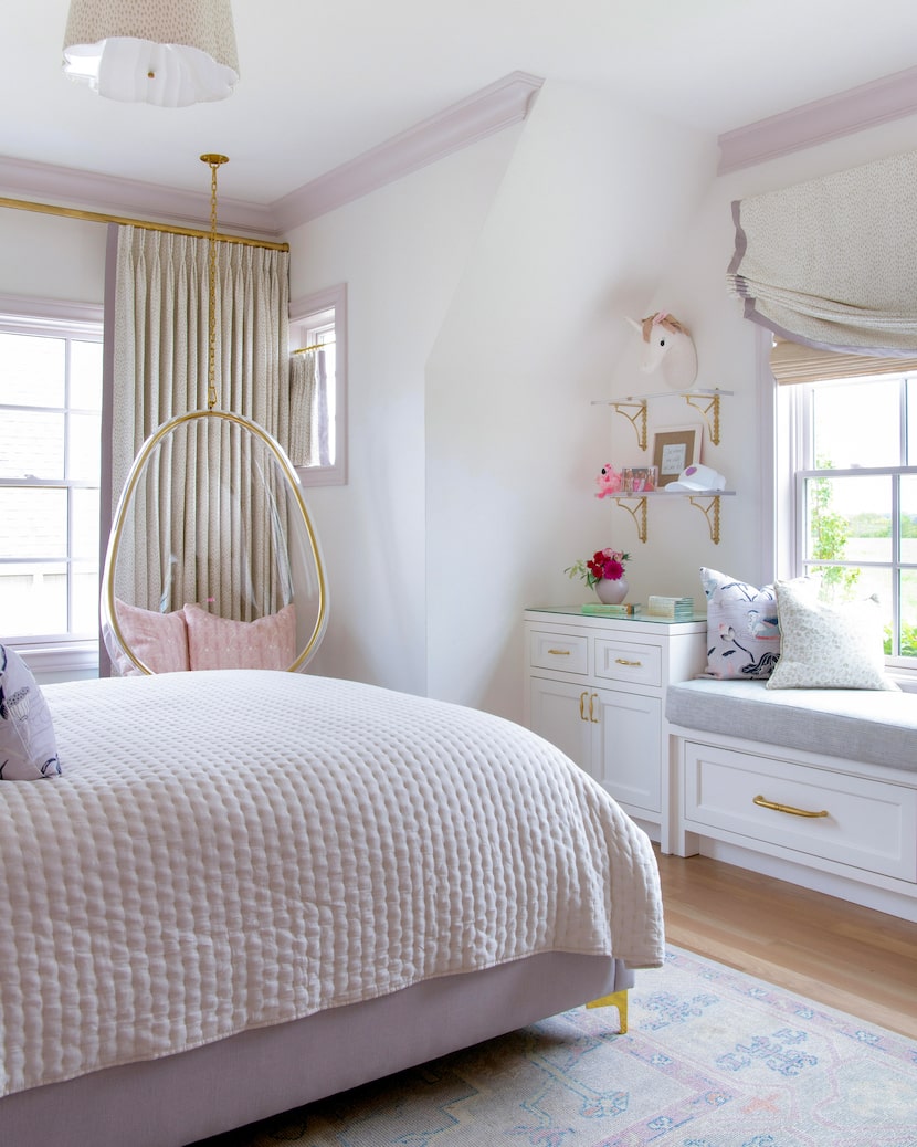 A white bedroom has purple trim and a bed with purple bedding.