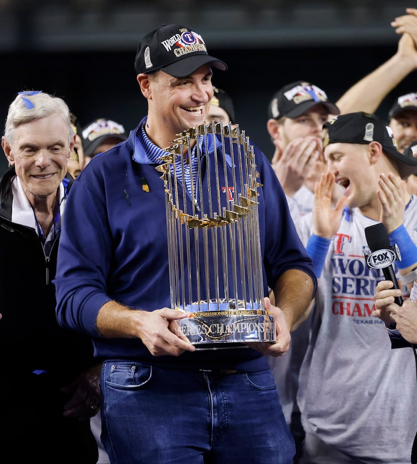 Texas Rangers general manager Chris Young is presented the World Series trophy during a post...