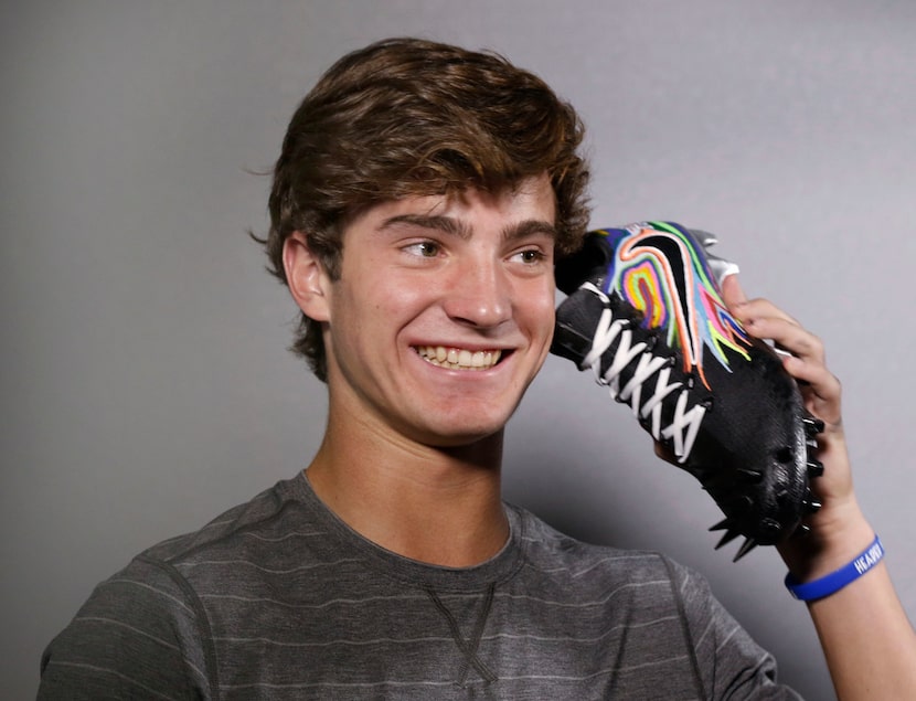 Luke Savage, 16, jokes around after spending about five hours painting a pair of cleats for...