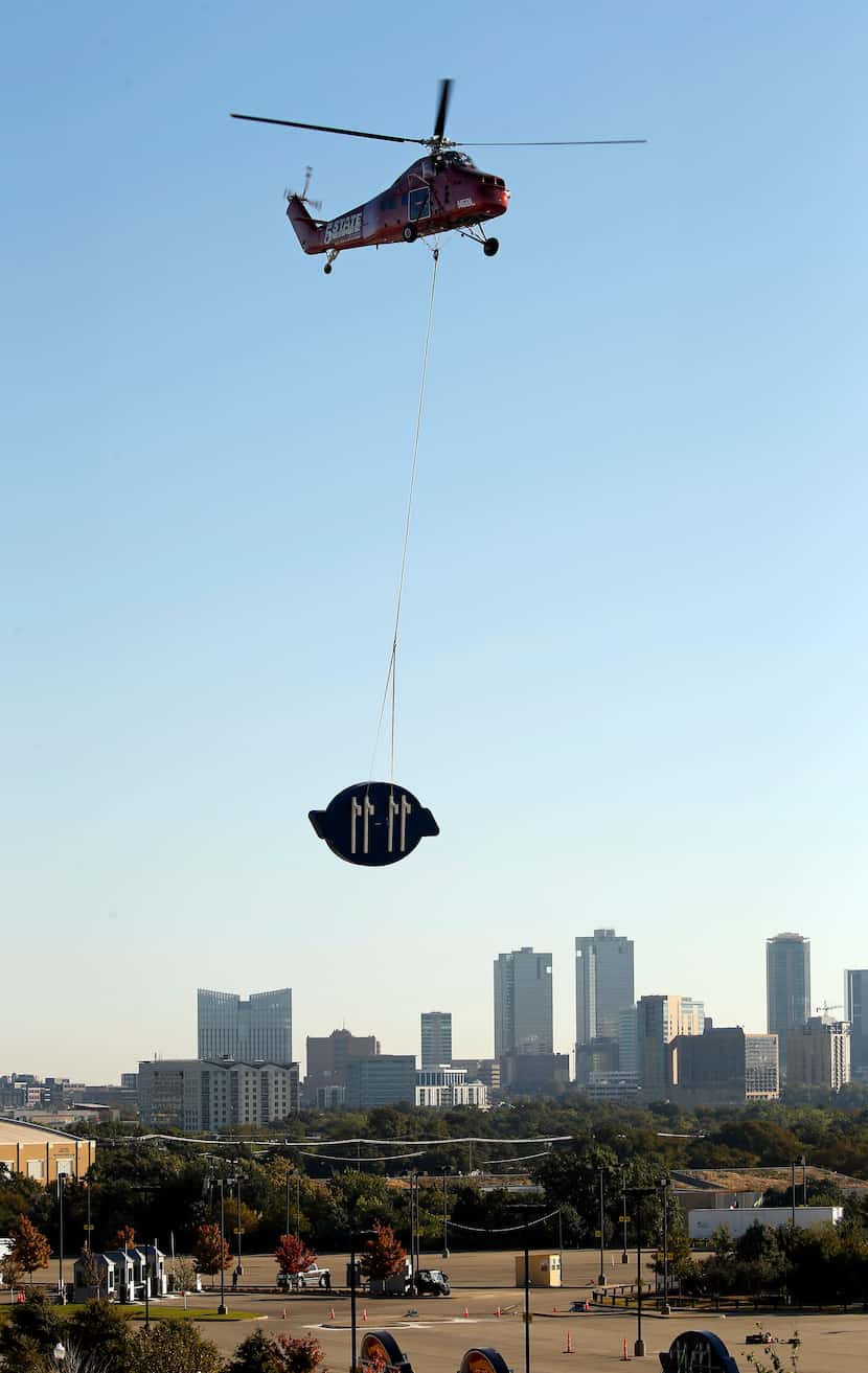 Before the Fort Worth skyline, a 5 State Helicopters crew lifted a Dickies logo to be placed...