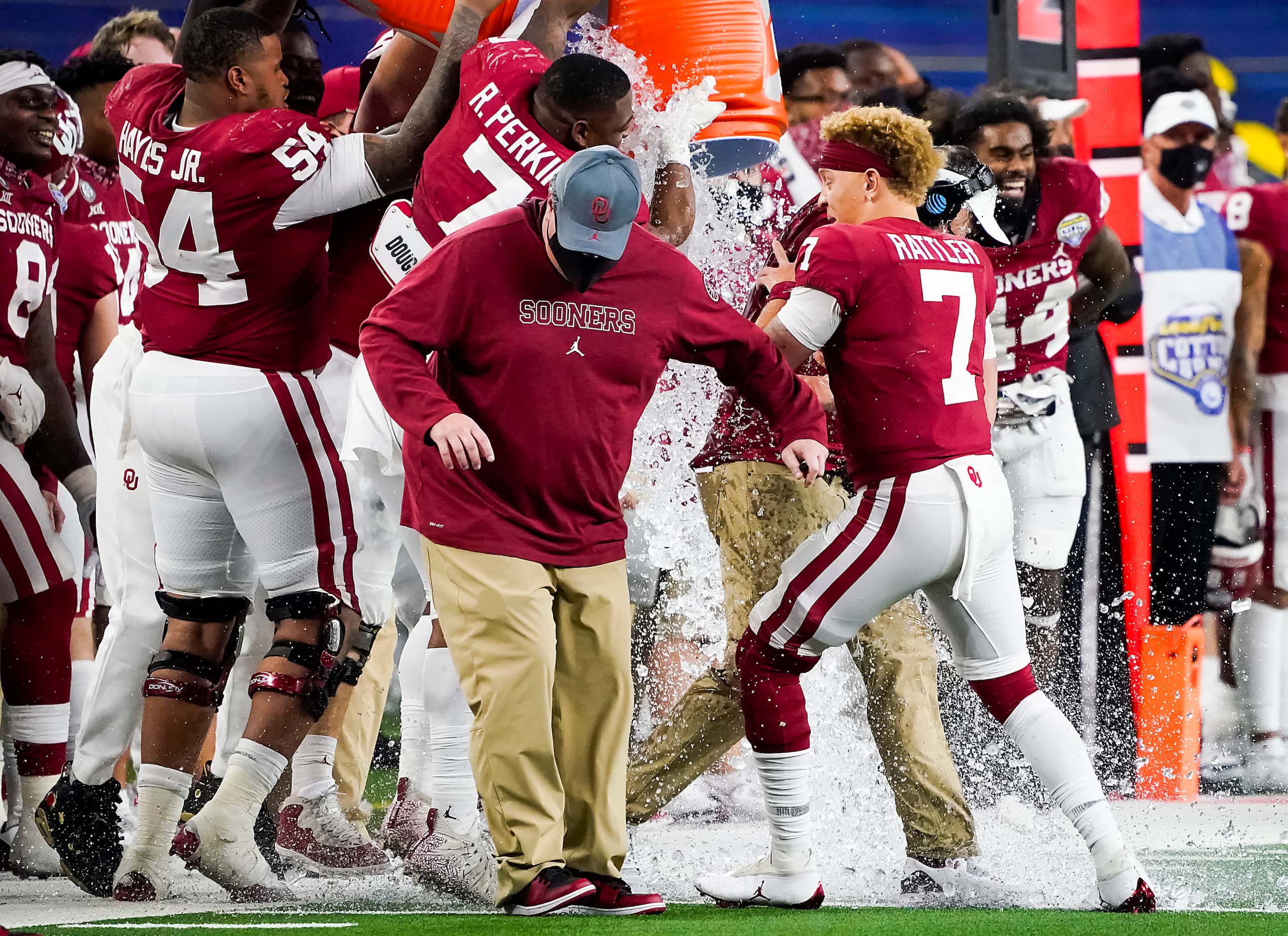 Oklahoma quarterback Spencer Rattler (7) holds onto head coach Lincoln Riley as he is doused...