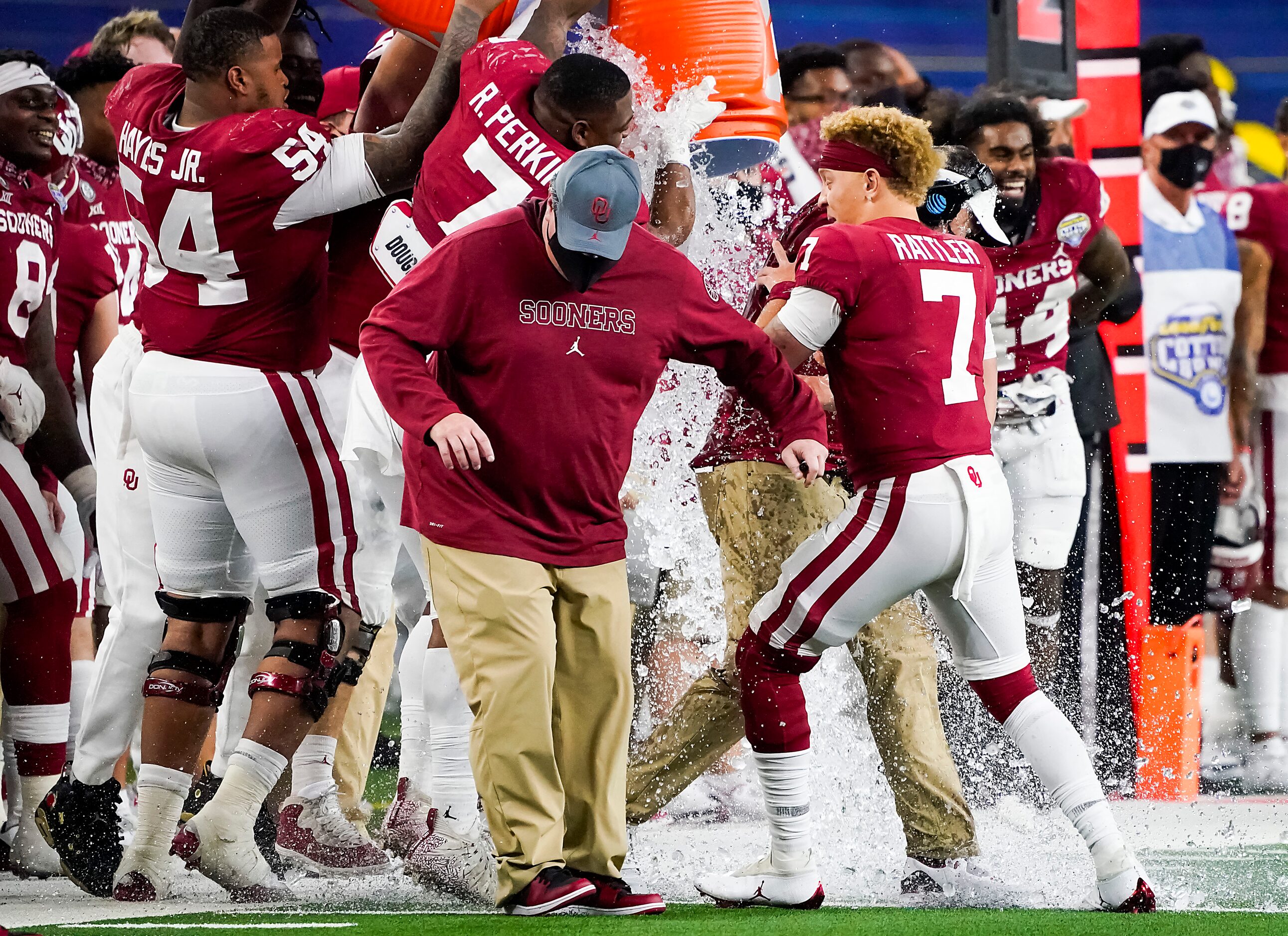 Oklahoma quarterback Spencer Rattler (7) holds onto head coach Lincoln Riley as he is doused...