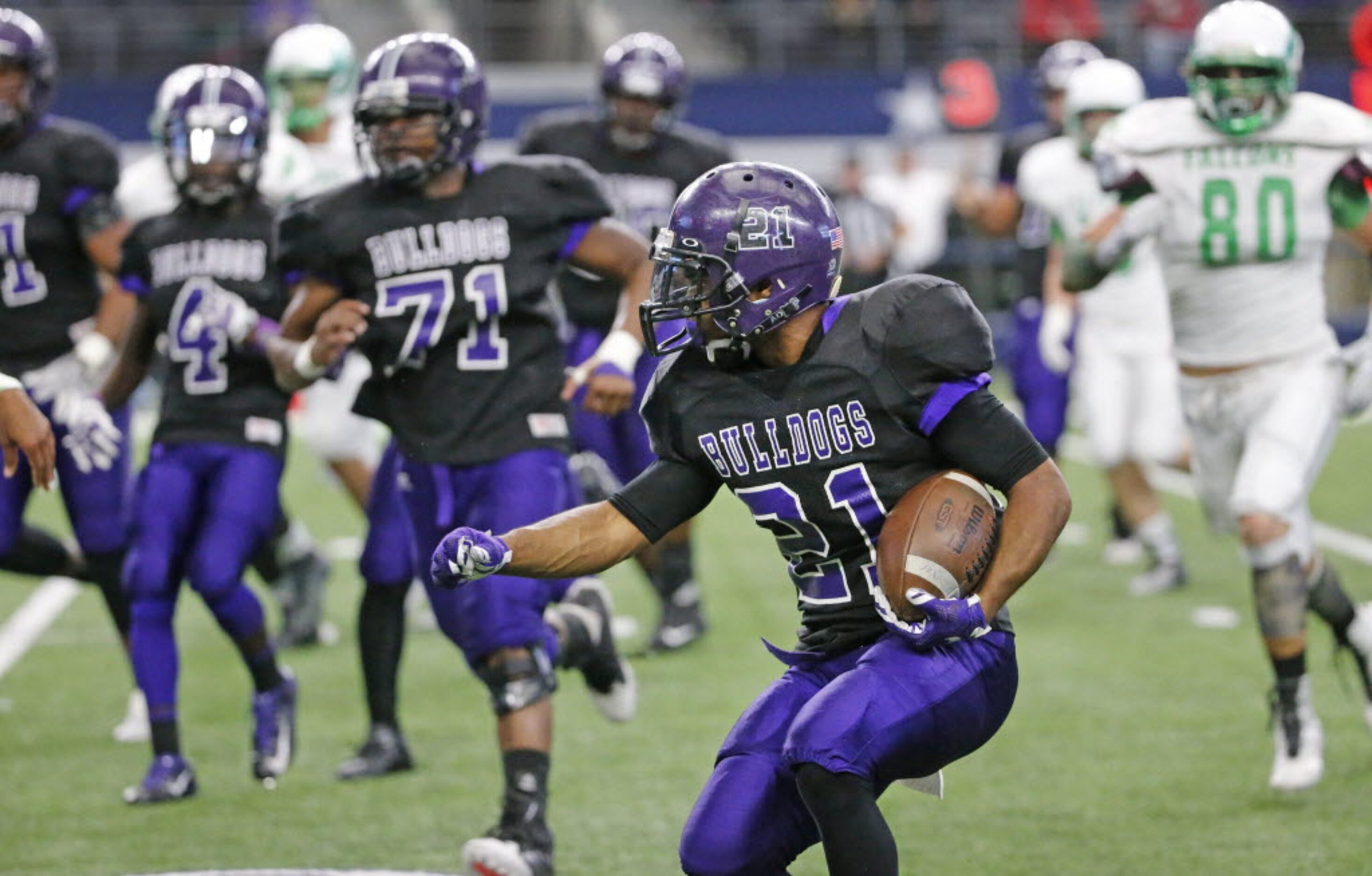 Everman running back Kierre Crossley (21) looks for running room behind a convoy of blockers...