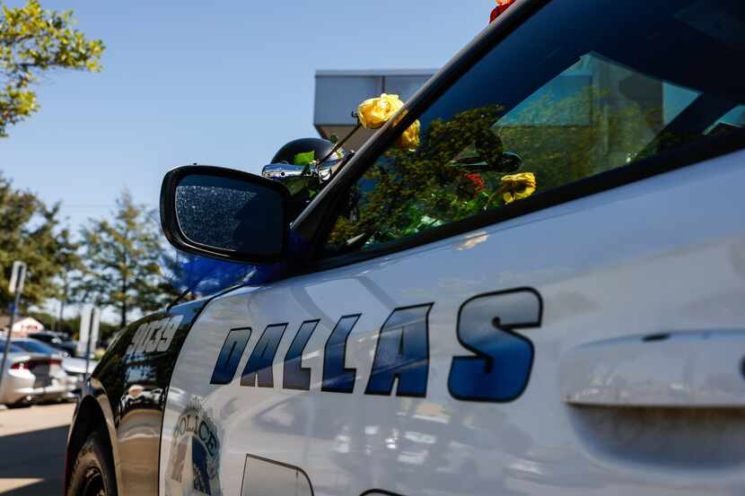 A Dallas Police car outside the northwest station stands as a memorial for Officer Jacob...