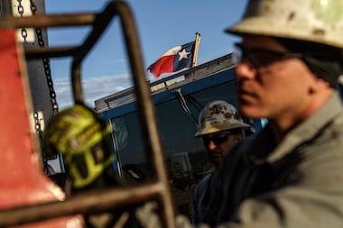 The Texas flag flies above workers at Latshaw oil drilling rig #43 in the Permian Basin in...
