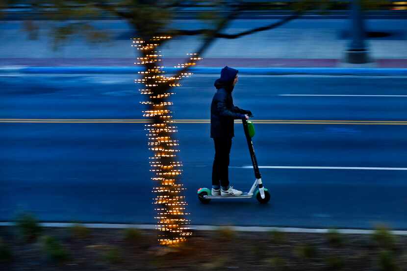 A bundled-up scooter rider breezed down Main Street in downtown Dallas as temperatures...