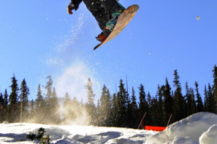A snowboarder takes off on the opening day at  Arapahoe Basin in Colorado. A-Basin is part...