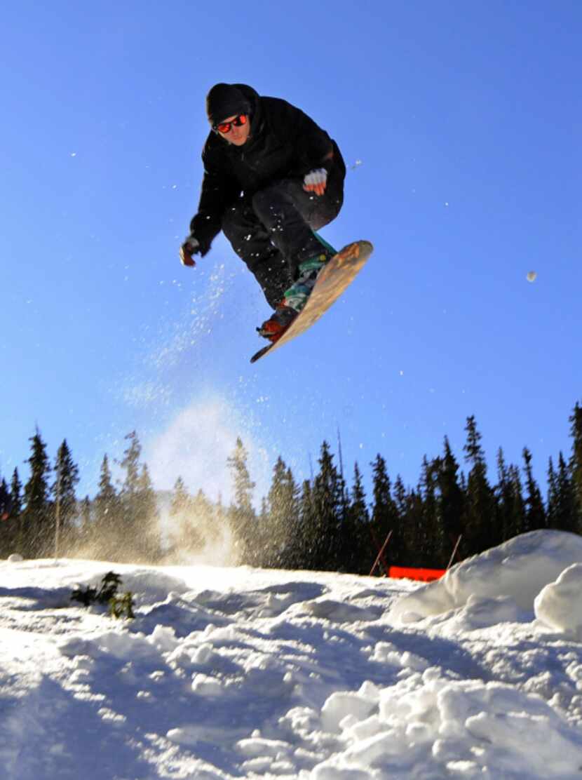 A snowboarder takes off on the opening day at  Arapahoe Basin in Colorado. A-Basin is part...