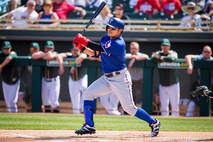 Texas Rangers outfielder Shin-Soo Choo singles in the first inning of a spring training...