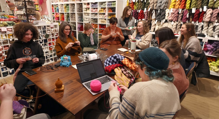 A group of young crafters enjoy conversations shared as they gathered to work on projects at...