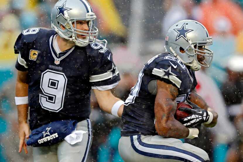 Dallas Cowboys quarterback Tony Romo (9) hands off to running back Darren McFadden during...