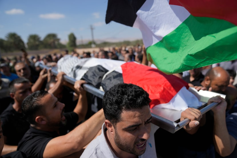 Mourners carry the body of Sameh al-Asali, 38, a Palestinian worker from Gaza who had been...