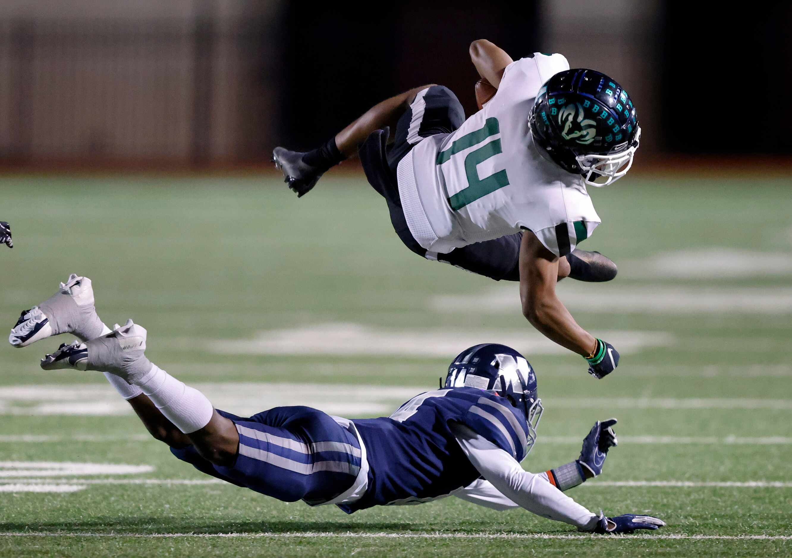 Richardson Berkner wide receiver Jamaal Saine (14) has his feet taken out from under him by...