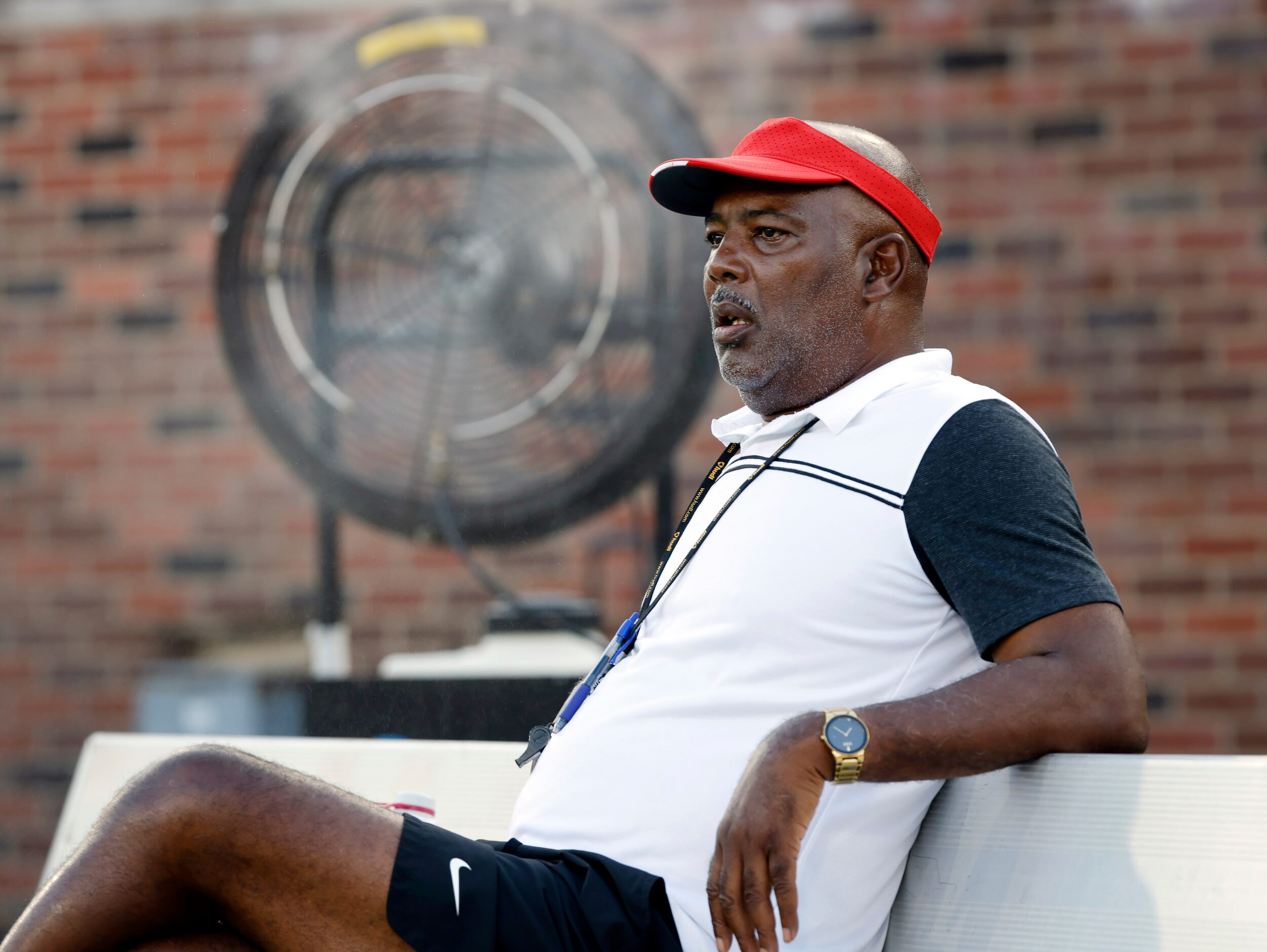 Duncanville head coach Reginald Samples keeps cool on the bench in front of a mister as he...