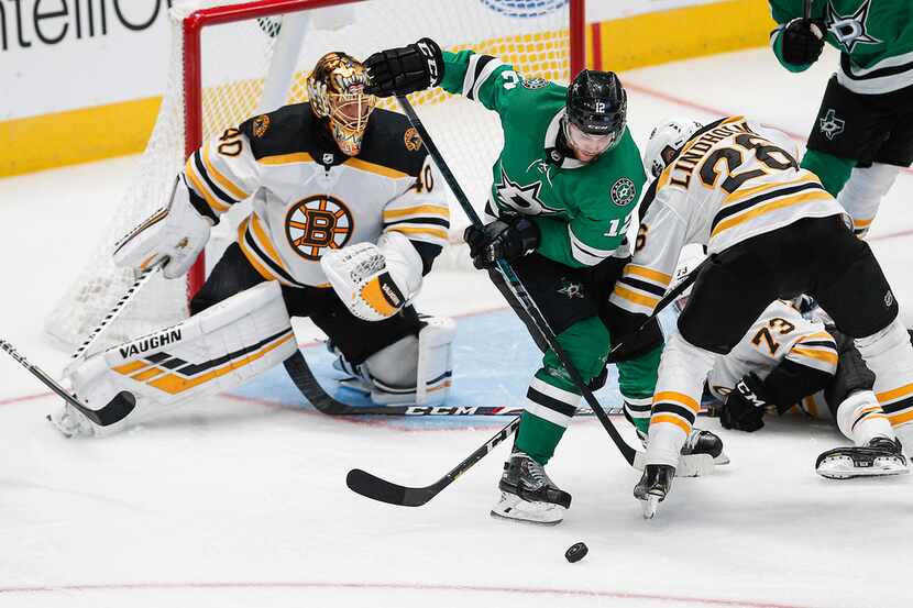 Boston Bruins goaltender Tuukka Rask (40) watches as forward Par Lindholm (26) works against...