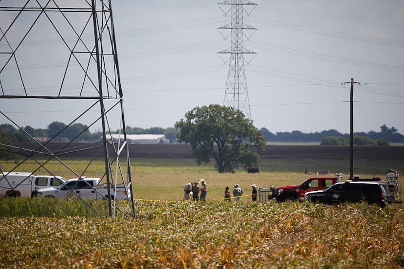 Investigators surround the scene in a field near Lockhart, Texas where a hot air balloon...