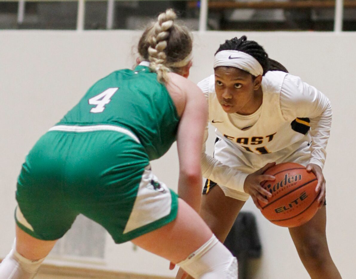 Plano East guard Kayla Cooper (11) eyes the defense of Southlake Carroll guard Brittney...