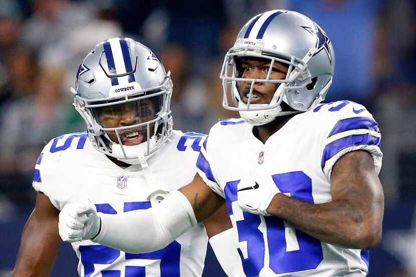FILE - Cowboys safety Xavier Woods (25, left) celebrates a pass breakup by cornerback...