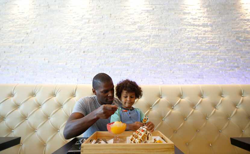 Dudley Bell and Jordan, 3, try out Mango Mango Desserts during the Plano shop's soft opening...