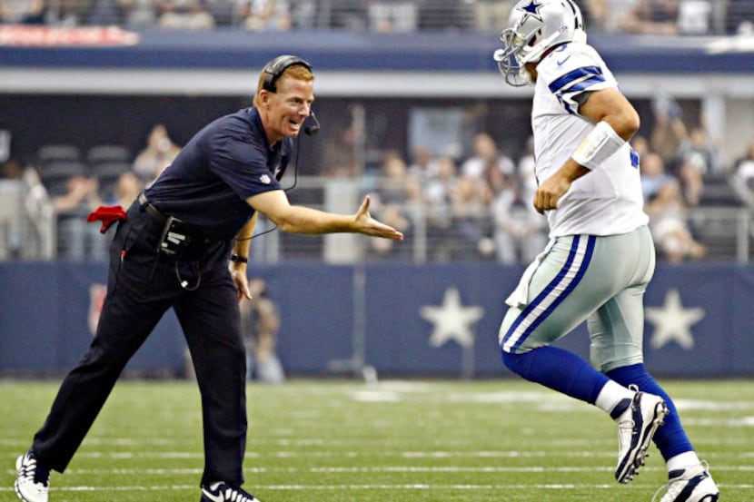 Dallas Cowboys head coach Jason Garrett (left) high-fives quarterback Tony Romo after a...