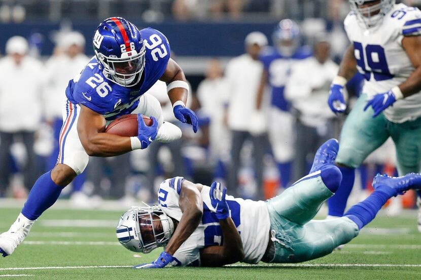 Dallas Cowboys free safety Xavier Woods (25) trips up New York Giants running back Saquon...