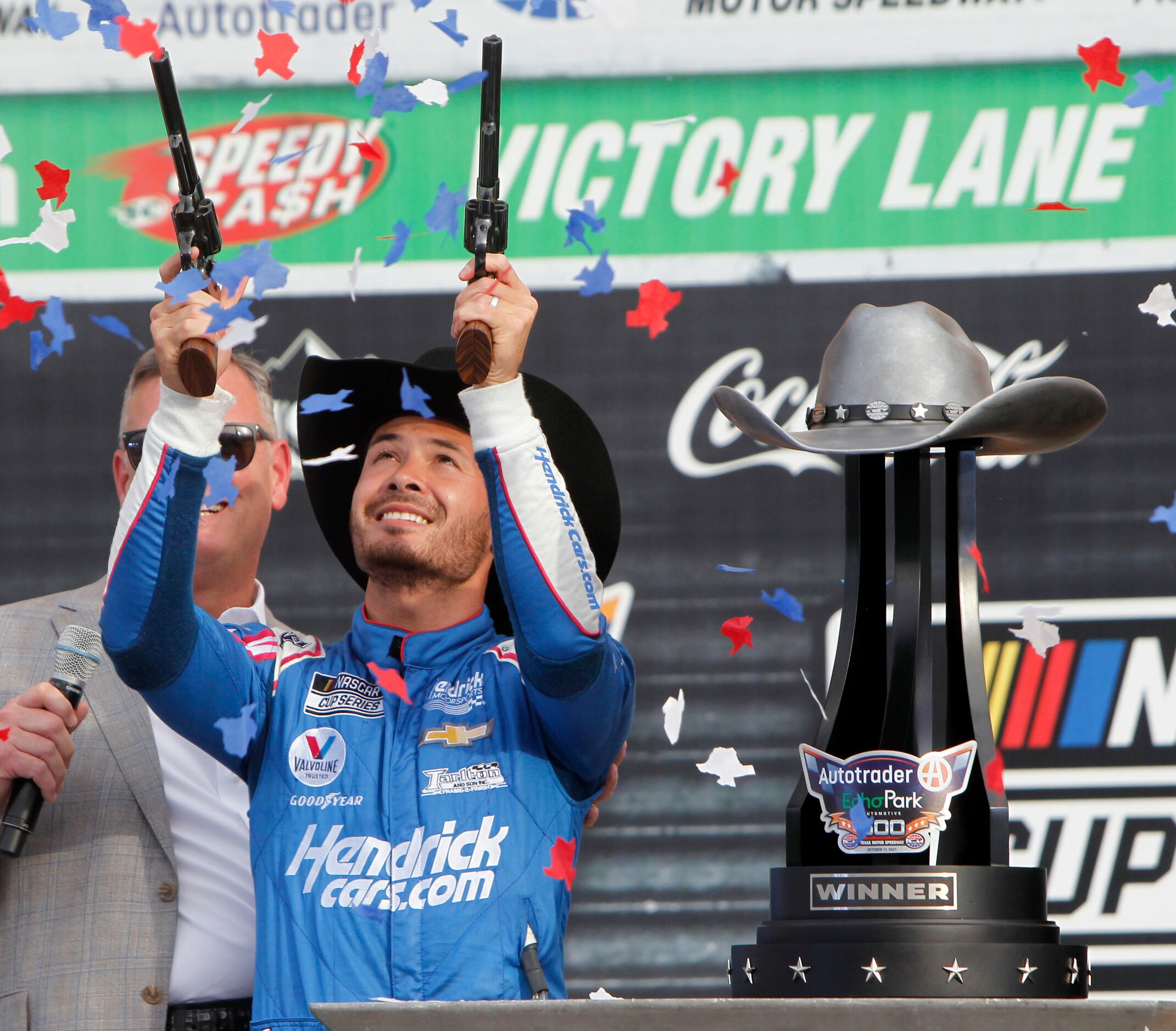 Kyle Larson fires a pair of pistols as he celebrates his win on Victory Lane. The NASCAR...