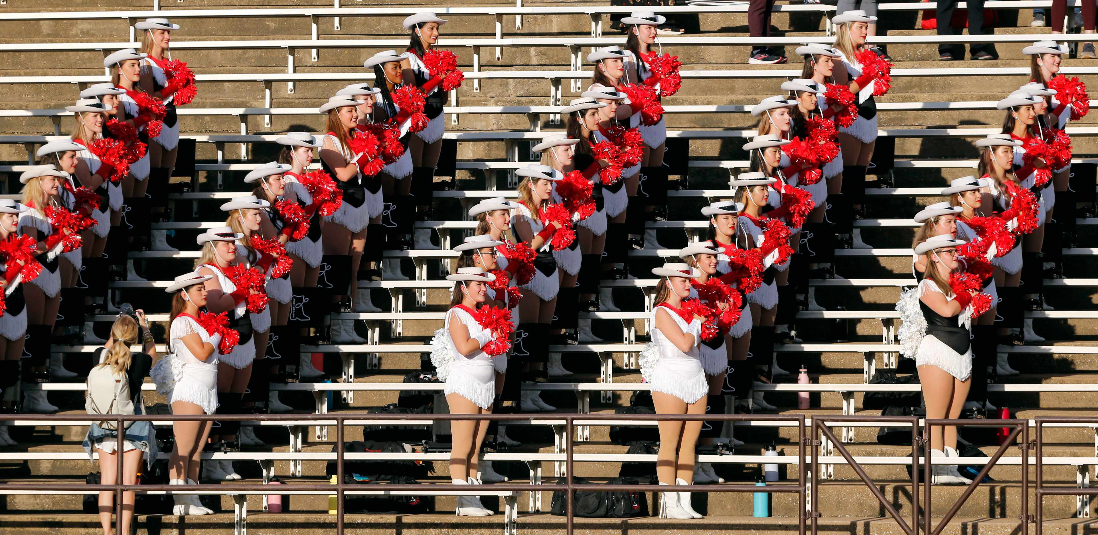 The Coppell high drill team stands for the national anthem before the start of a high school...