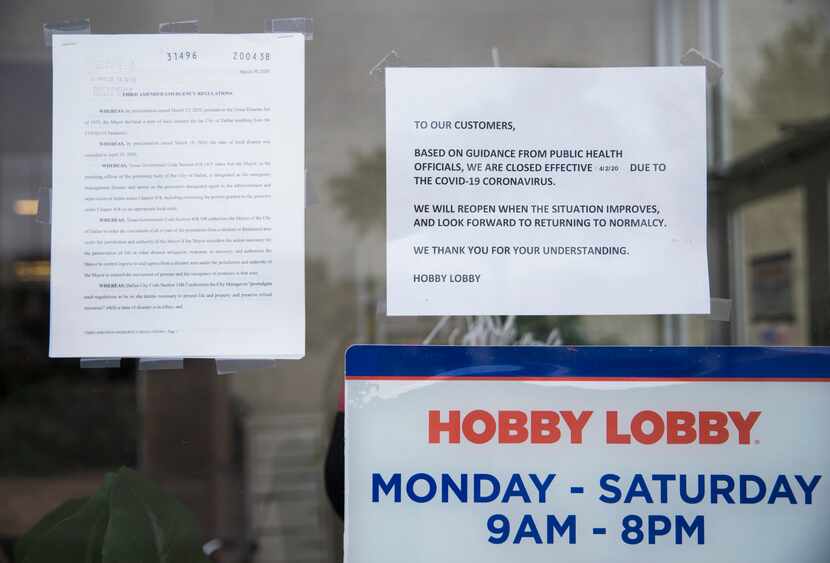 Signs are posted at the front entrance of Hobby Lobby on Preston Road in Dallas. 