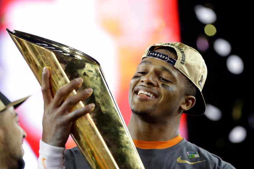 Clemson's Deshaun Watson holds up the championship trophy after the NCAA college football...