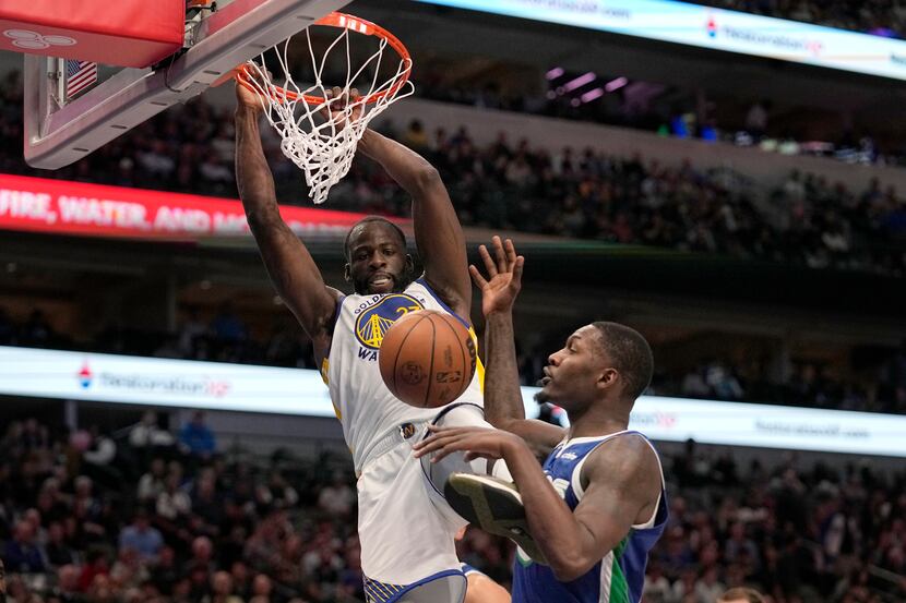 Golden State Warriors forward Draymond Green dunks the ball over Dallas Mavericks forward...