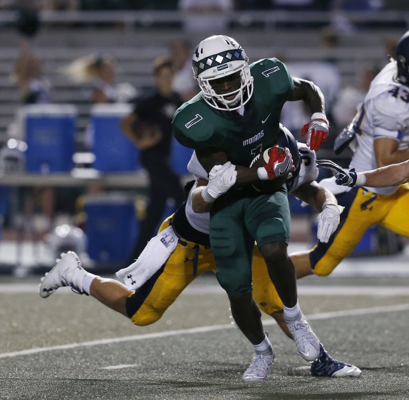 Waxahachie receiver Jalen Reagor (1) is tackled by Highland Park defensive player Bennett...