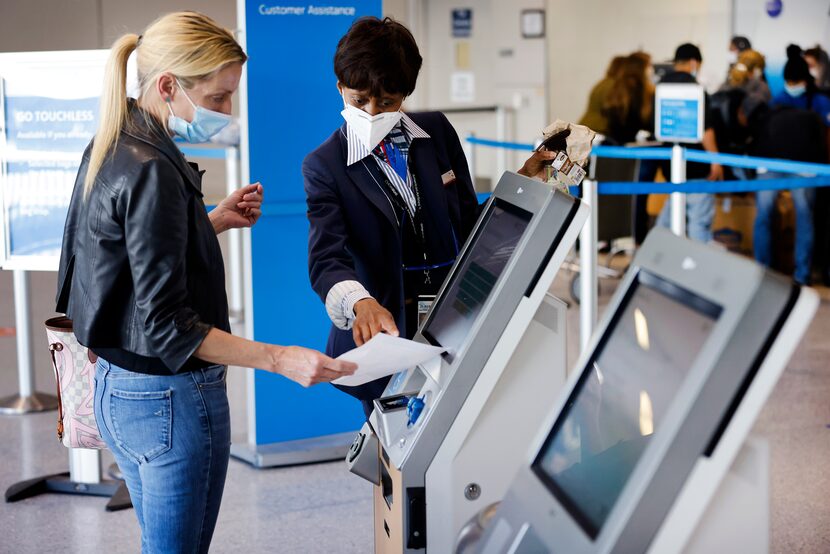 American Airlines customer assistance representative Rhonda Jameson assists a passenger...