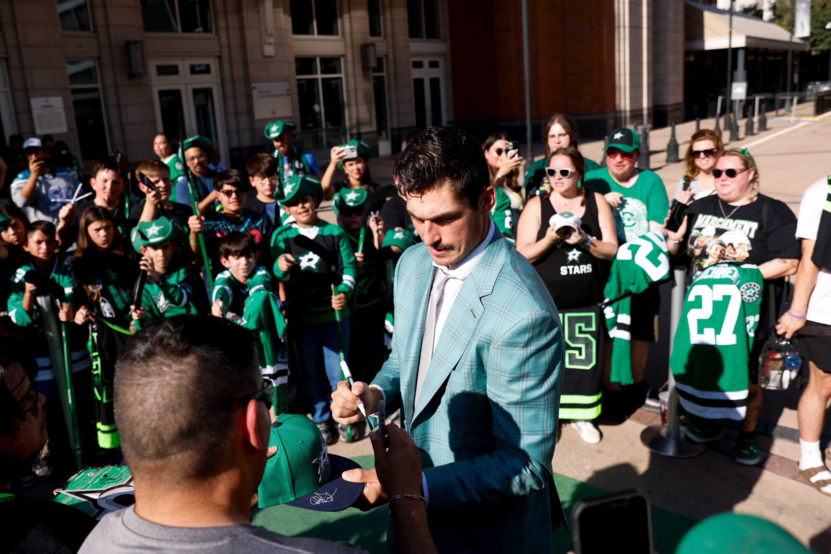 Dallas Stars left wing Mason Marchment gives autograph to fans during the team’s home opener...