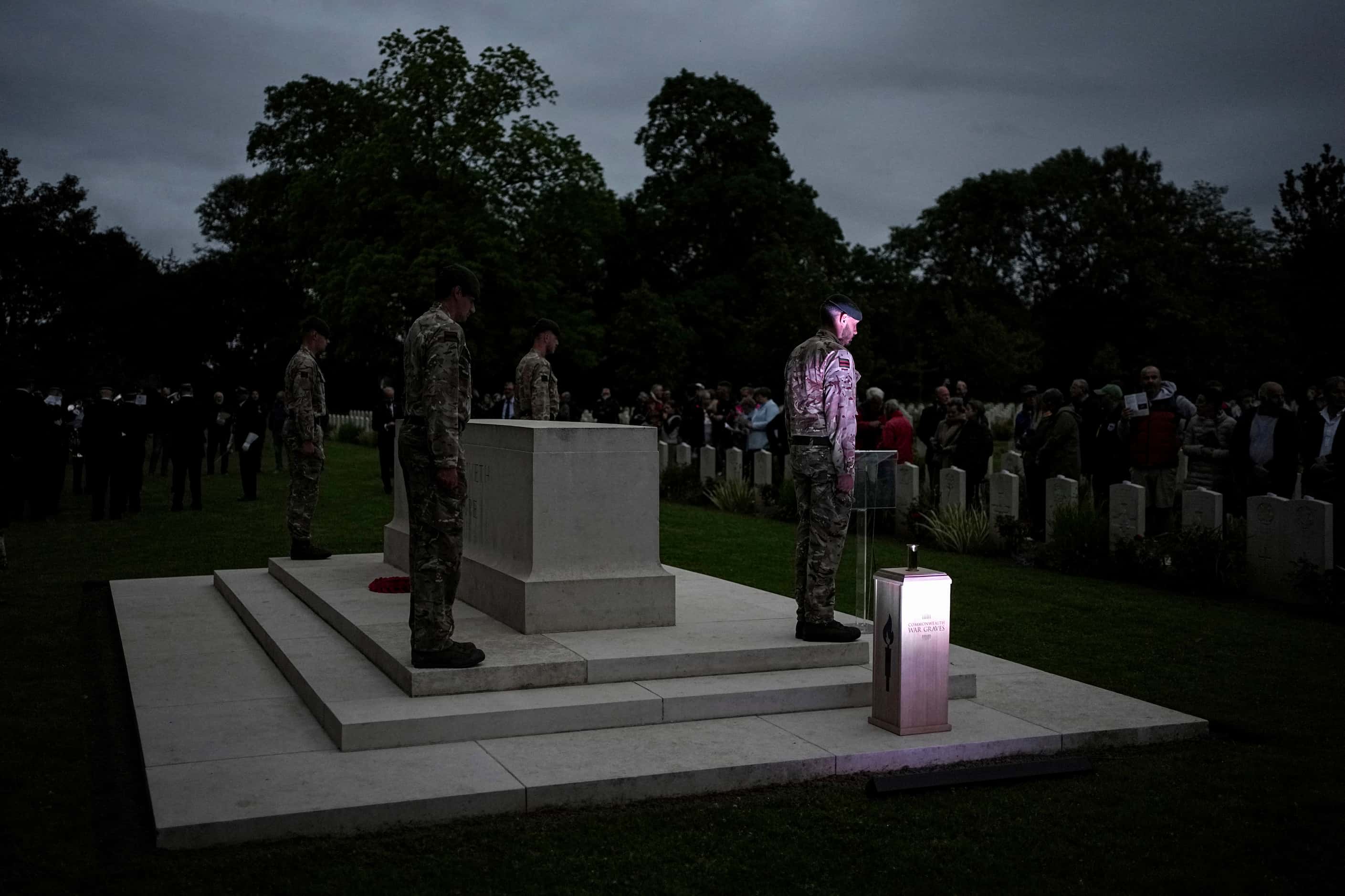 Soldiers stand during a ceremony at the Commonwealth war cemetery of Banneville-La-Campagne,...