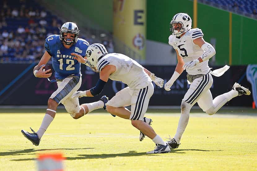 MIAMI, FL - DECEMBER 22: Paxton Lynch #12 of the Memphis Tigers carries as Skye PoVey #7 and...