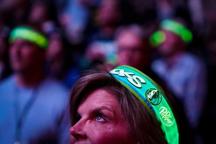 Dallas Mavericks fans wear lighted headbands before an NBA basketball game against the...