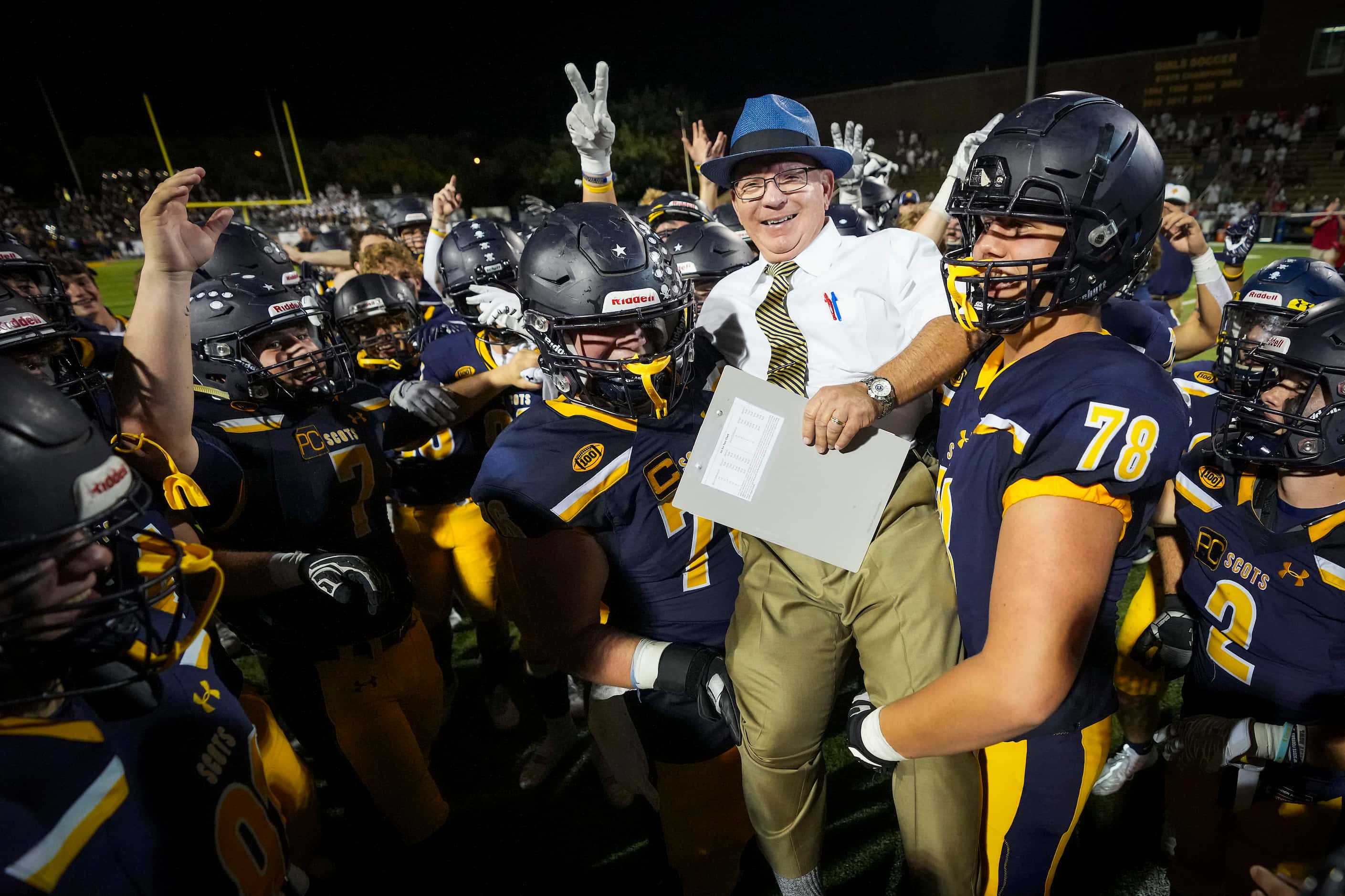 Highland Park head coach Randy Allen is lifted up by his players after a victory over Lake...