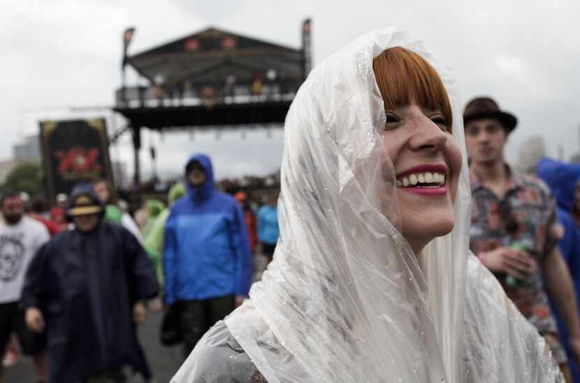A concert-goer watches a band perform and endures rainy weather at the Shaky Knees Music...
