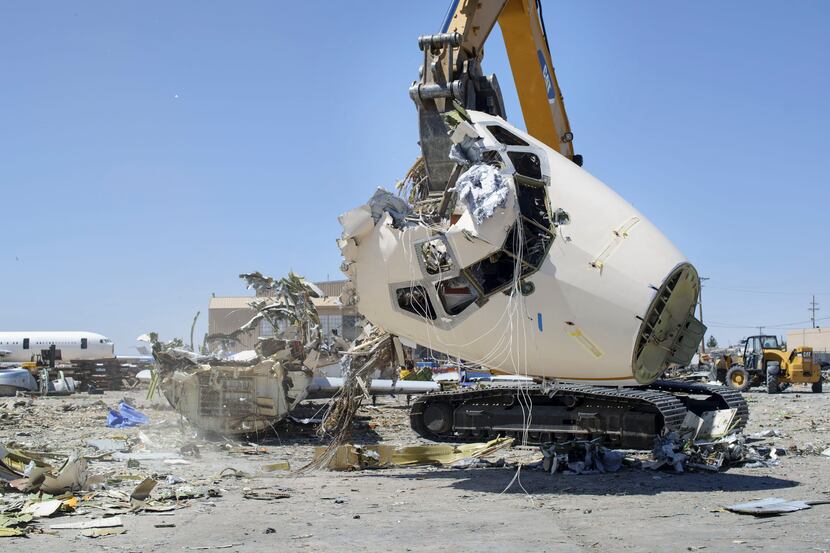 Jacob Sedillo of Custom Construction LLC operates the crusher to destroy an older airplane...